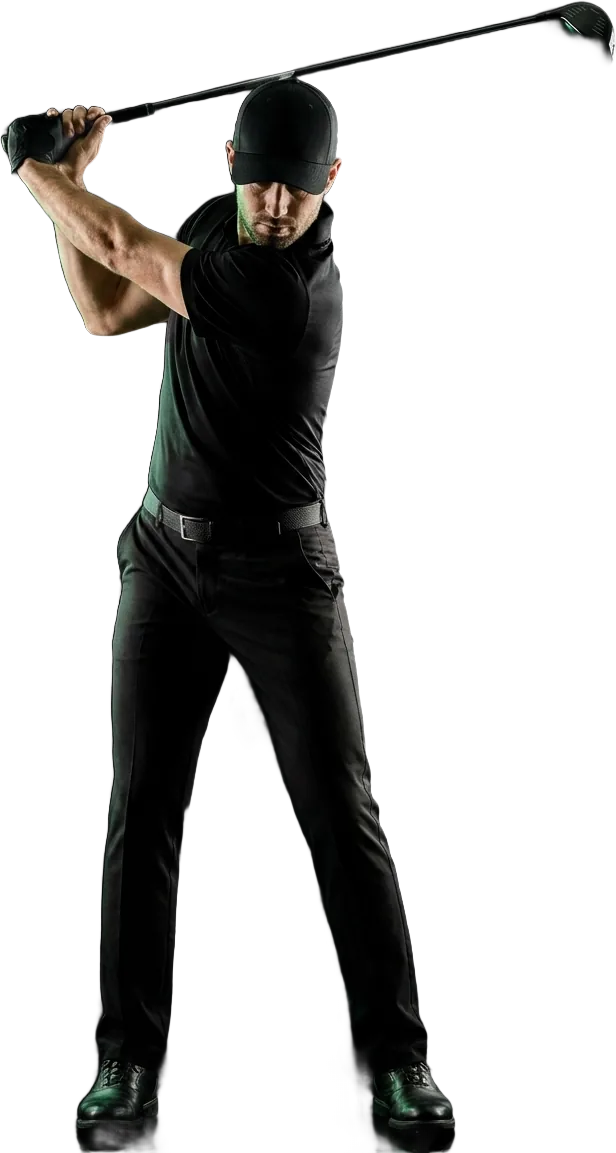 A golfer in black kit at the top of the backswing, lit from the side under floodlights